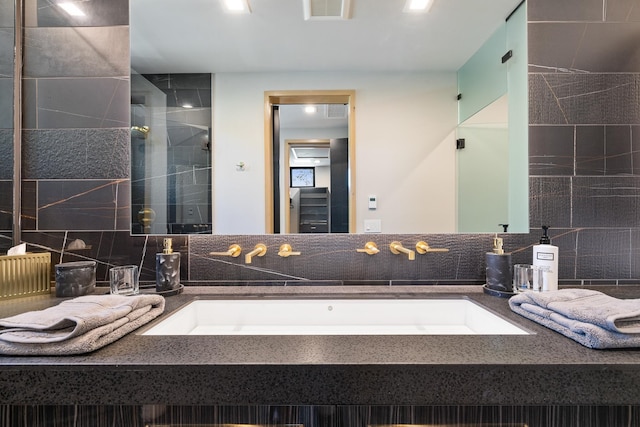 bathroom featuring vanity, visible vents, a shower stall, and decorative backsplash