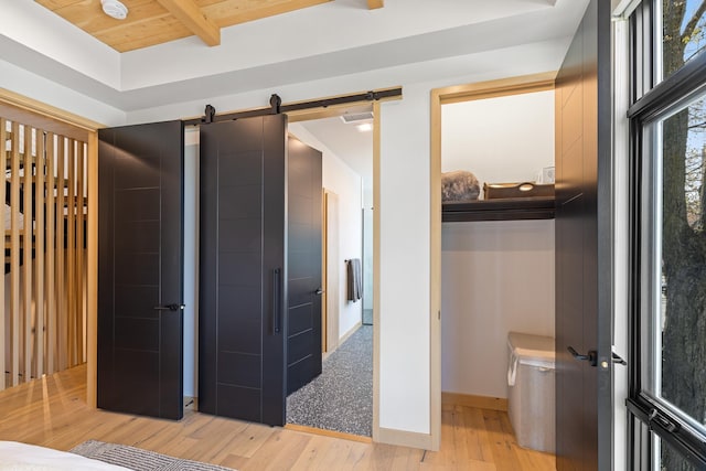 interior space with beam ceiling, wood finished floors, visible vents, and baseboards