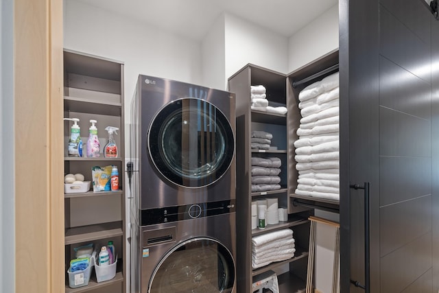 clothes washing area featuring stacked washer / drying machine and laundry area