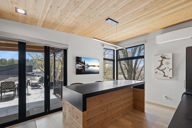 interior space with an AC wall unit, wooden ceiling, baseboards, and light wood-type flooring