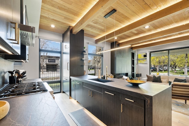 kitchen featuring a sink, beam ceiling, light wood-style floors, and wood ceiling