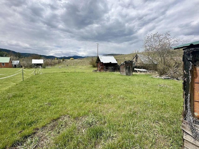 view of yard with a rural view and an outbuilding