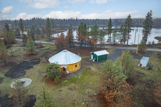 drone / aerial view with a water view and a wooded view