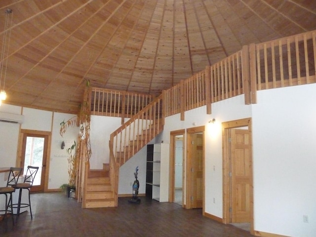interior space with a high ceiling, baseboards, and wood finished floors