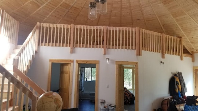 living area with high vaulted ceiling, wooden ceiling, beam ceiling, and stairway