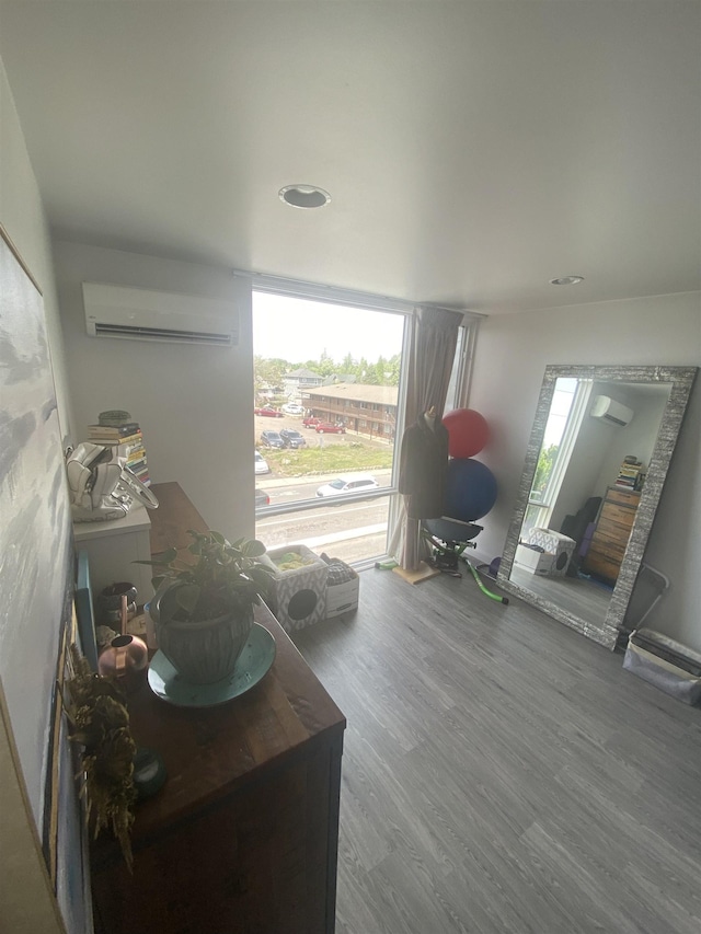 sitting room featuring recessed lighting, a wall mounted AC, and wood finished floors