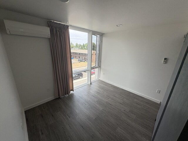 904 E Indiana Ave, Spokane, WA 99207 - spare room featuring a wall mounted AC, dark wood-style flooring, and recessed lighting