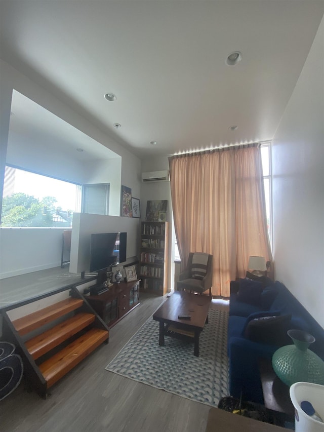 living room with wood finished floors, recessed lighting, and a wall unit AC