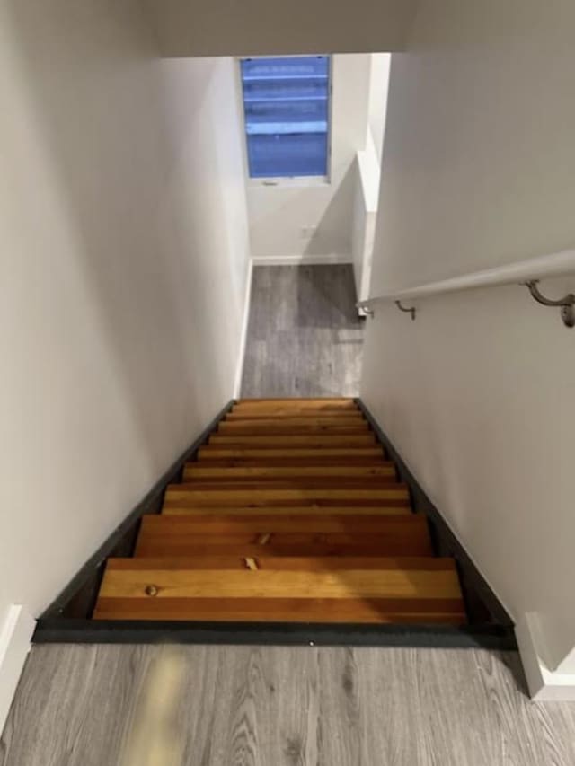 stairway with baseboards and wood finished floors