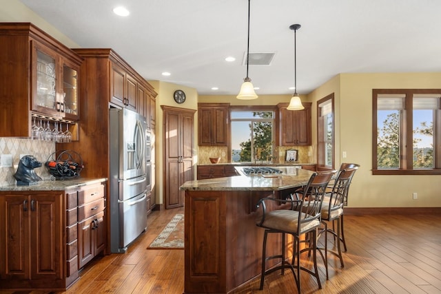 kitchen featuring decorative backsplash, stainless steel appliances, and hardwood / wood-style floors