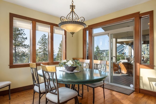 dining space featuring baseboards and light wood-style flooring
