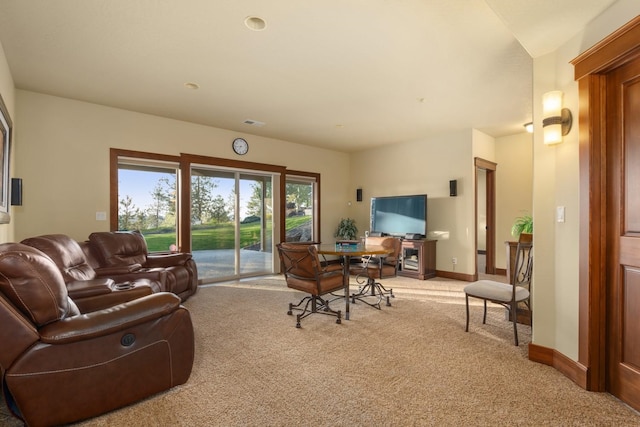 living area featuring baseboards and light carpet