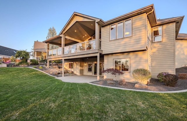 back of property featuring a lawn, a balcony, and a patio
