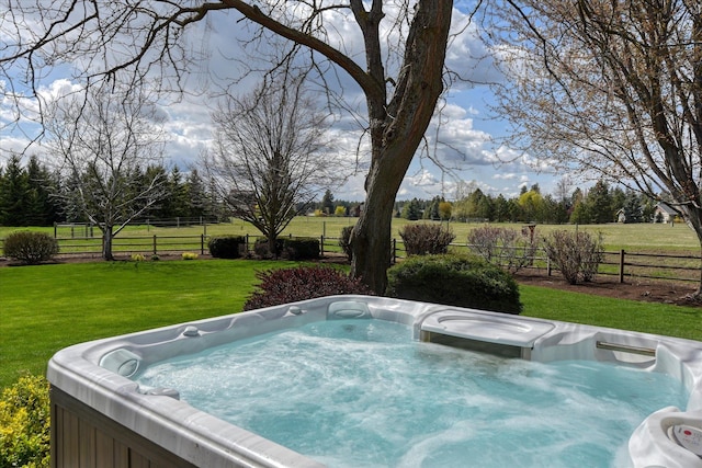 view of swimming pool with a hot tub, fence, and a yard