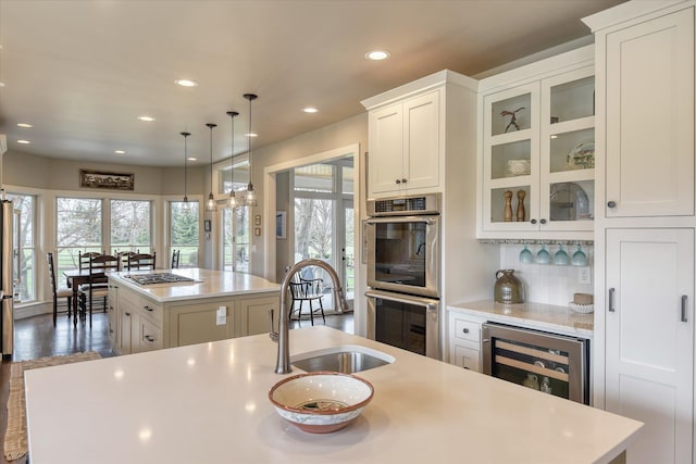 kitchen with light countertops, plenty of natural light, stainless steel appliances, wine cooler, and a kitchen island