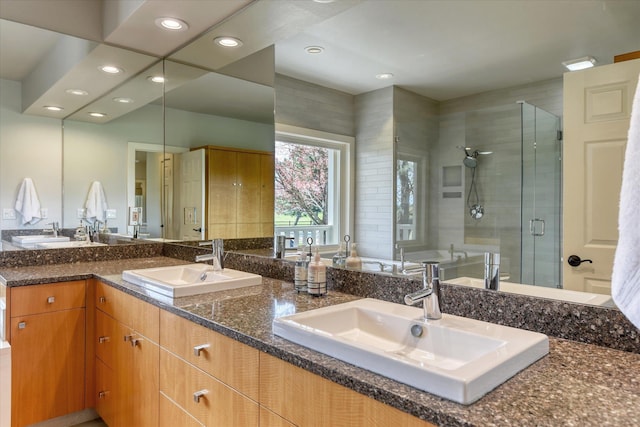 bathroom featuring a sink, a stall shower, recessed lighting, and double vanity