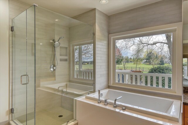 bathroom featuring a shower stall and a garden tub