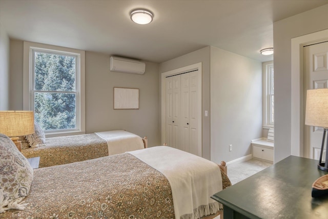 carpeted bedroom featuring baseboards, a wall unit AC, and a closet