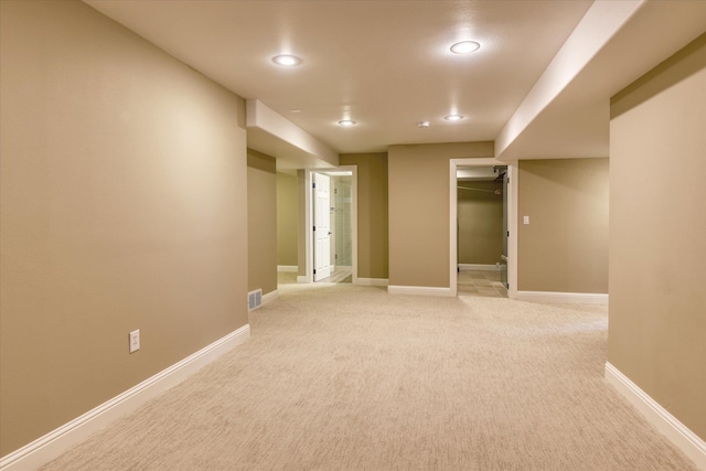 spare room with light colored carpet, recessed lighting, and baseboards