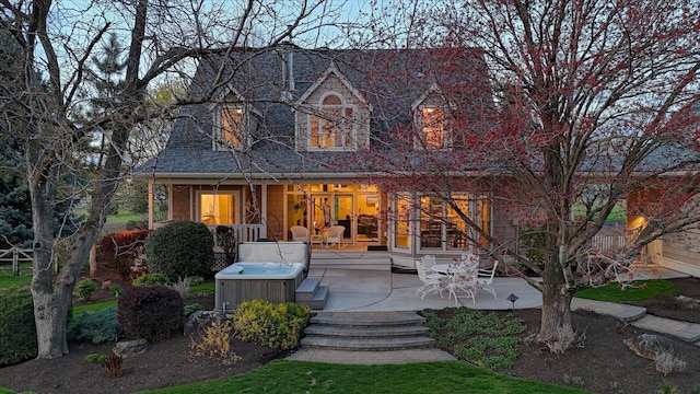 view of front of home featuring a hot tub and a patio