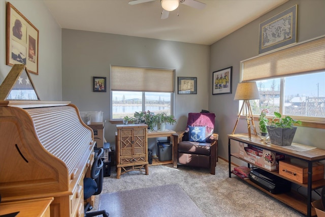 carpeted home office with a ceiling fan and a healthy amount of sunlight