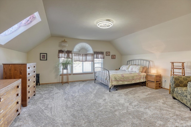 carpeted bedroom with baseboards and vaulted ceiling with skylight