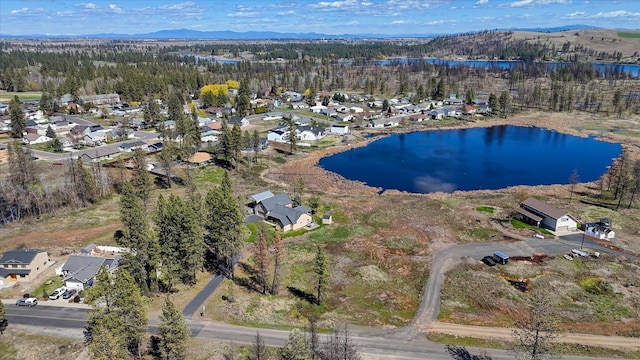 bird's eye view featuring a residential view, a water and mountain view, and a forest view