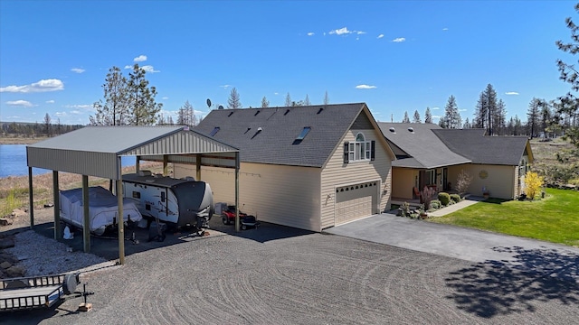 view of front facade featuring a garage, a front lawn, and aphalt driveway