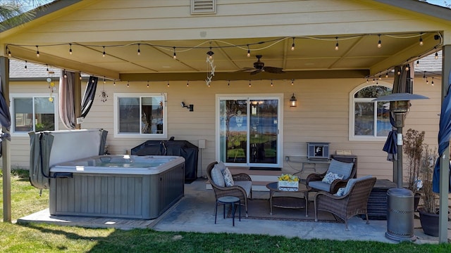 view of patio featuring ceiling fan, a hot tub, and visible vents