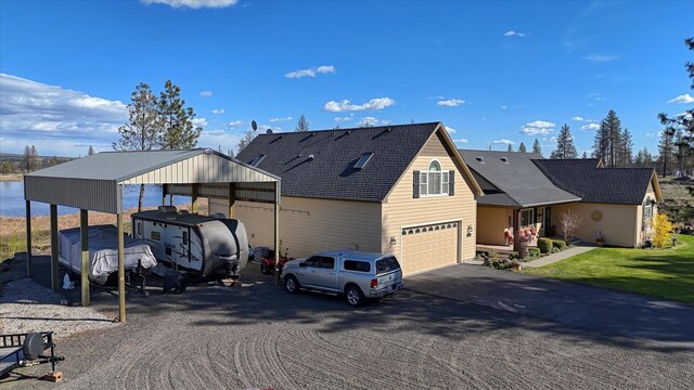 view of front of home with an attached garage, driveway, and a carport