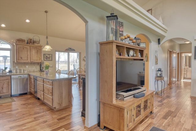 kitchen with stainless steel dishwasher, arched walkways, light brown cabinetry, and light wood finished floors