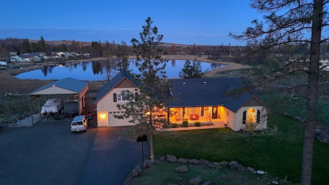 view of front of home featuring a water view, driveway, a front lawn, and a garage