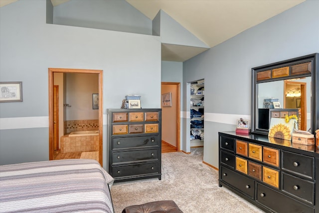 bedroom featuring light colored carpet, vaulted ceiling, and ensuite bathroom