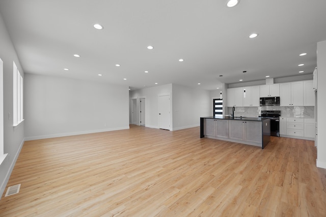3621 W Montgomery Rd, Deer Park, WA 99006 - kitchen with open floor plan, range with electric cooktop, black microwave, and visible vents