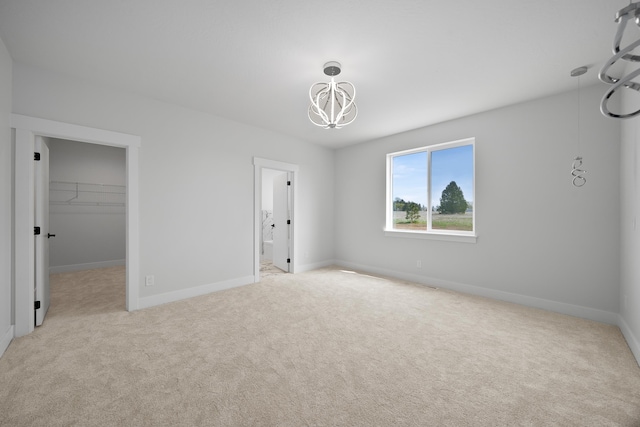 3621 W Montgomery Rd, Deer Park, WA 99006 - unfurnished bedroom with an inviting chandelier, baseboards, a walk in closet, carpet flooring, and ensuite bath