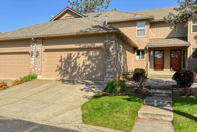 view of front of property with concrete driveway, a shingled roof, and a garage