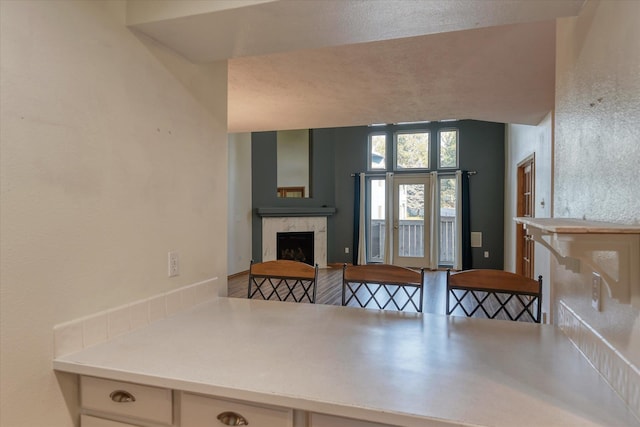 kitchen featuring light countertops, vaulted ceiling, and a tile fireplace