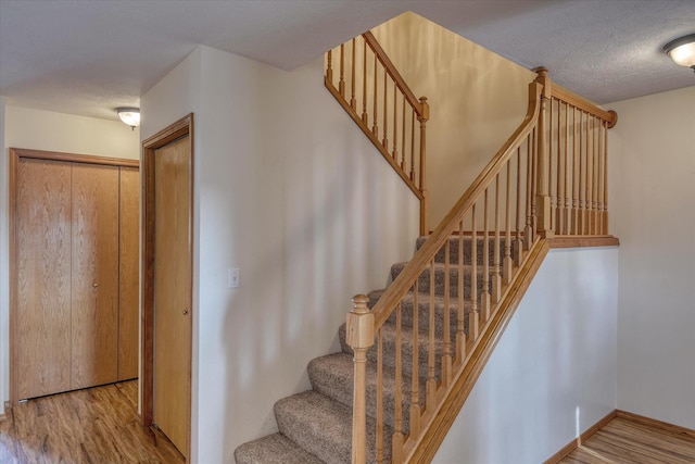 stairway with baseboards and wood finished floors