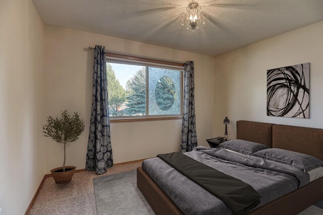 bedroom with baseboards, carpet, and a textured ceiling
