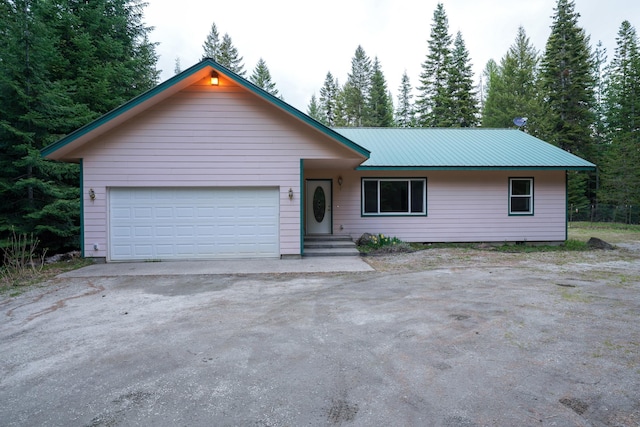 ranch-style house with an attached garage and metal roof