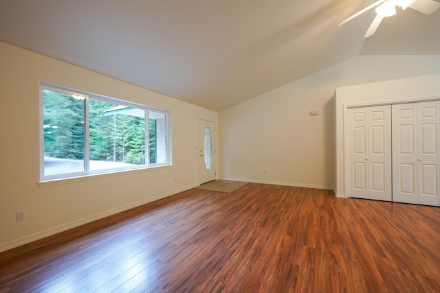 unfurnished living room with baseboards, ceiling fan, vaulted ceiling, and wood finished floors
