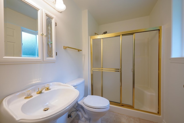 bathroom featuring a sink, tile patterned flooring, a shower stall, and toilet