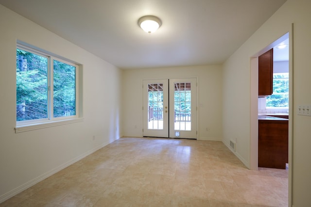 empty room featuring baseboards, french doors, and visible vents