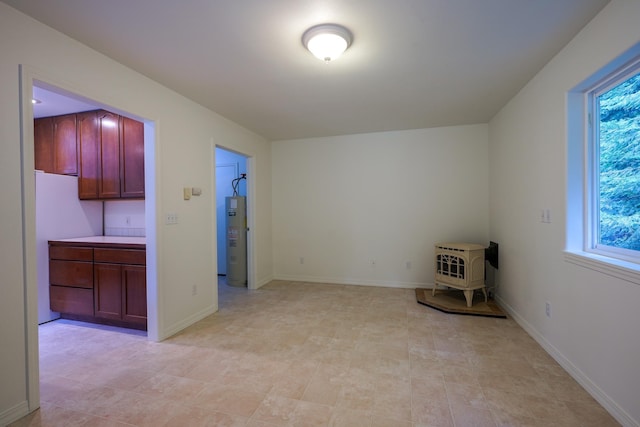spare room with baseboards and a wood stove