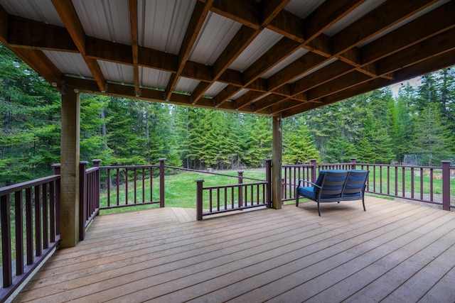 deck with a lawn and a view of trees