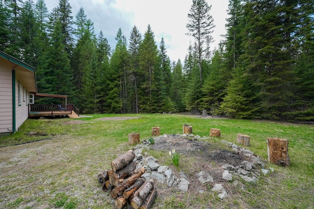 view of yard with a wooden deck and a wooded view