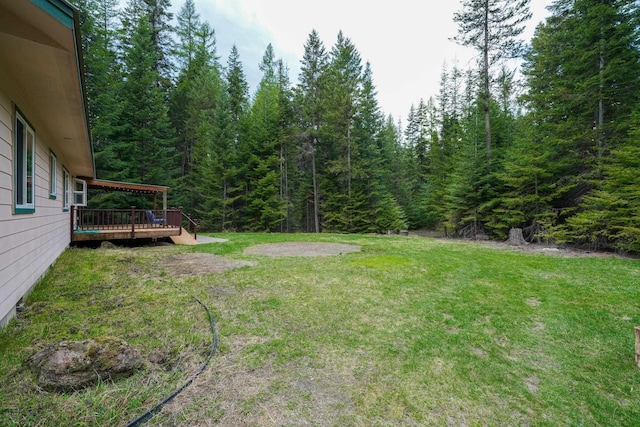 view of yard with a deck and a forest view