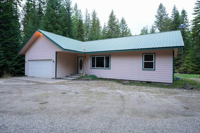 single story home with metal roof and a garage