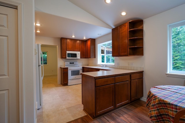 kitchen featuring a sink, open shelves, a wealth of natural light, and white appliances