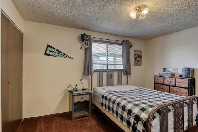 2121 E Upriver Dr # 19, Spokane, WA 99207 - bedroom with a closet, a textured ceiling, and dark colored carpet